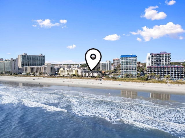 birds eye view of property with a water view and a beach view