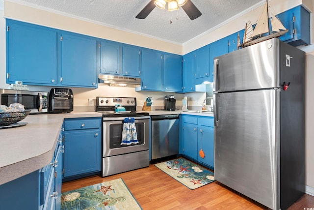 kitchen featuring a textured ceiling, stainless steel appliances, blue cabinets, and light hardwood / wood-style floors