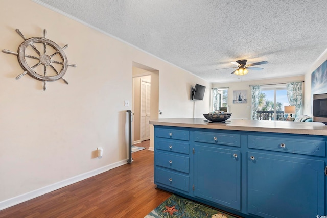 kitchen featuring a textured ceiling, dark hardwood / wood-style floors, blue cabinets, and ceiling fan