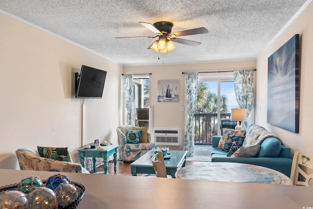 living room with a wall unit AC, ceiling fan, and a textured ceiling