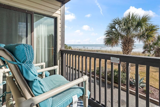 balcony featuring a water view and a beach view