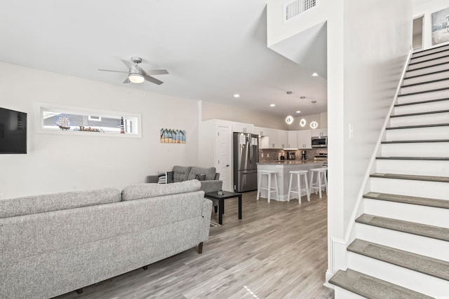 living room with ceiling fan and light hardwood / wood-style floors