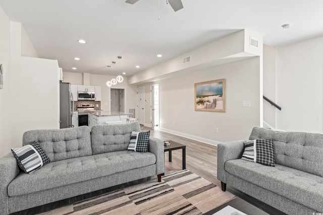 living room with ceiling fan and light wood-type flooring