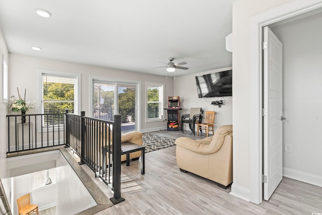 living room featuring light hardwood / wood-style flooring and ceiling fan