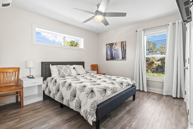 bedroom with multiple windows, dark hardwood / wood-style floors, and ceiling fan