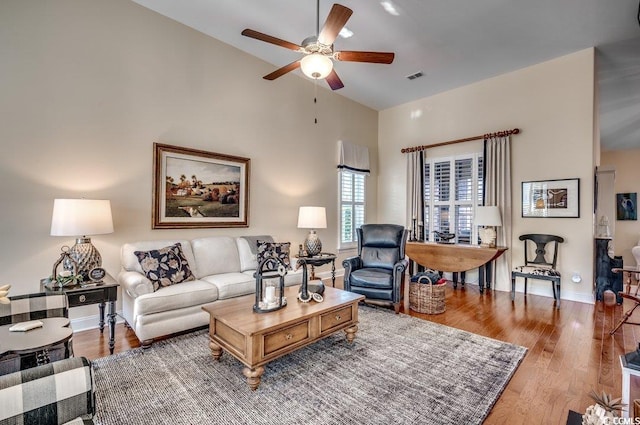 living room with high vaulted ceiling, light hardwood / wood-style flooring, and ceiling fan