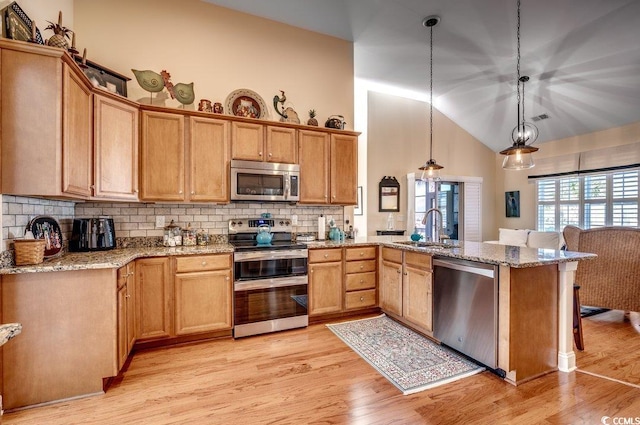 kitchen with decorative backsplash, sink, pendant lighting, and appliances with stainless steel finishes