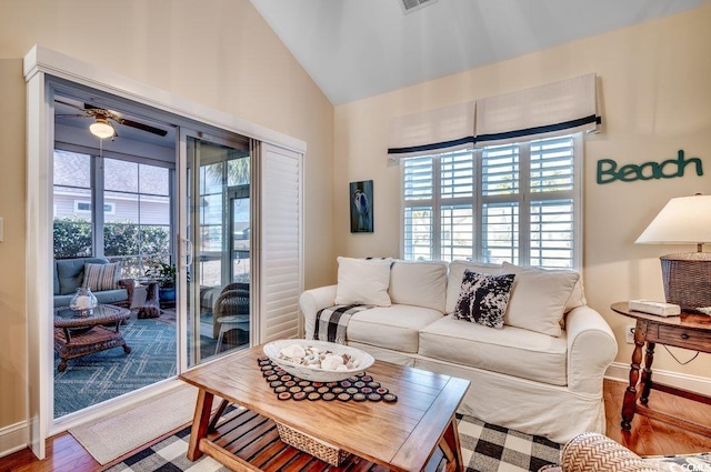 living room with ceiling fan, wood-type flooring, and lofted ceiling