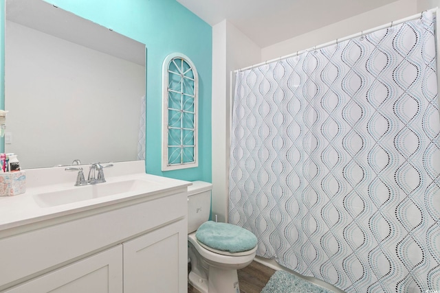 bathroom featuring hardwood / wood-style flooring, vanity, toilet, and walk in shower