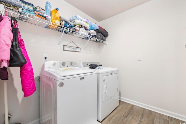 laundry area with independent washer and dryer and hardwood / wood-style flooring