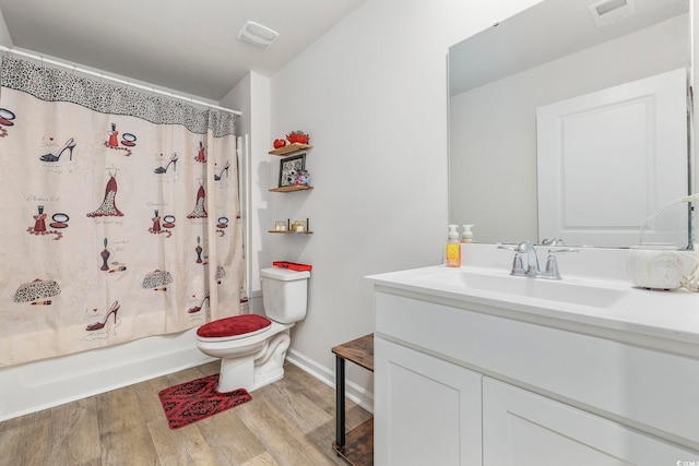 full bathroom featuring hardwood / wood-style floors, vanity, toilet, and shower / bath combo with shower curtain