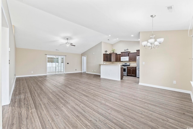 unfurnished living room featuring lofted ceiling, light hardwood / wood-style floors, and ceiling fan with notable chandelier