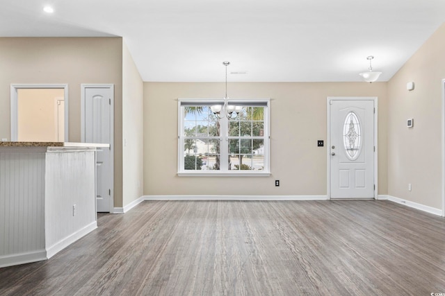 foyer with dark hardwood / wood-style floors and a chandelier