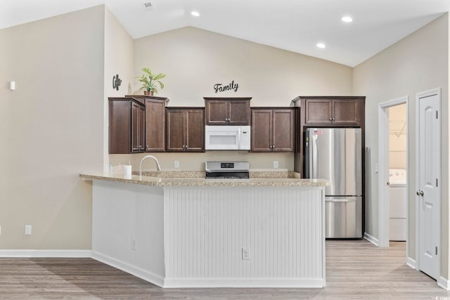 kitchen with stainless steel refrigerator, light stone countertops, kitchen peninsula, stove, and vaulted ceiling