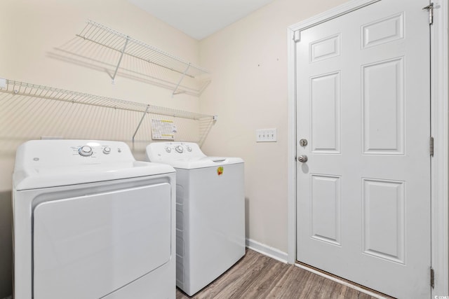 clothes washing area featuring separate washer and dryer and wood-type flooring