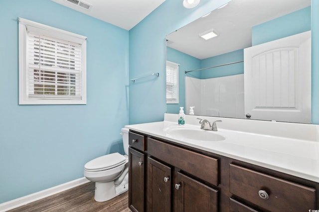 bathroom with vanity, toilet, wood-type flooring, and walk in shower