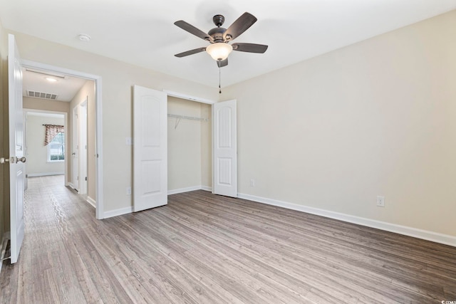 unfurnished bedroom with light wood-type flooring, a closet, and ceiling fan