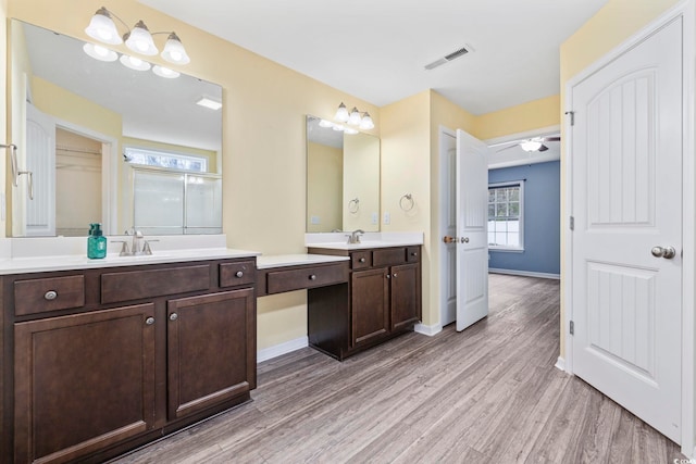 bathroom with hardwood / wood-style floors, vanity, and ceiling fan