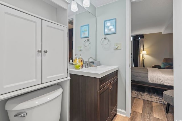 bathroom with vanity, toilet, and wood-type flooring