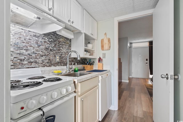 kitchen featuring backsplash, white appliances, sink, hardwood / wood-style floors, and white cabinetry