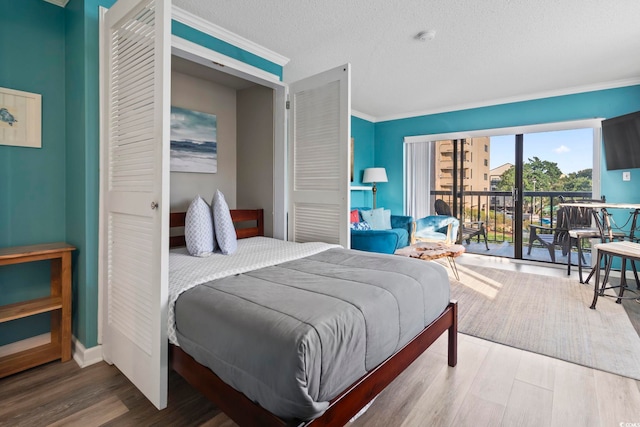 bedroom featuring access to exterior, crown molding, wood-type flooring, and a textured ceiling