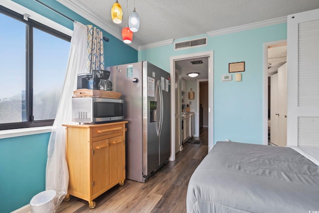 bedroom with a textured ceiling, crown molding, dark hardwood / wood-style flooring, and stainless steel refrigerator with ice dispenser