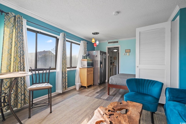 living room featuring a mountain view, light hardwood / wood-style floors, ornamental molding, and a textured ceiling