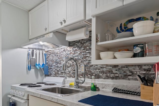 kitchen with sink, light stone countertops, range hood, tasteful backsplash, and white cabinetry