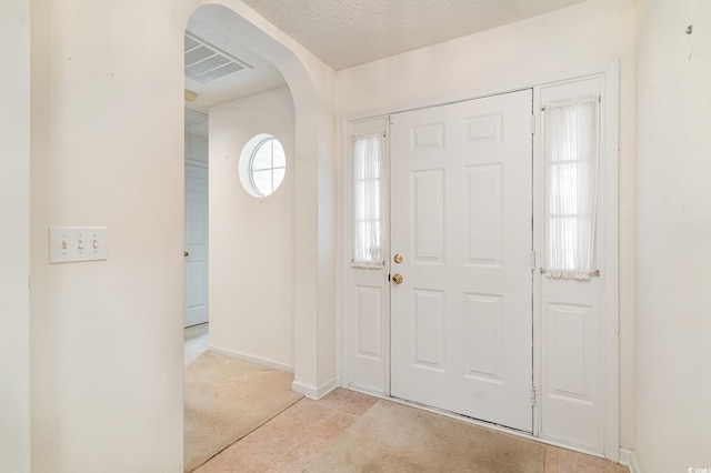 foyer entrance with a textured ceiling