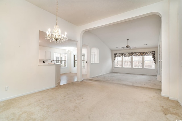 interior space featuring a wealth of natural light, ceiling fan with notable chandelier, light colored carpet, and lofted ceiling