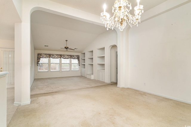 unfurnished living room with built in shelves, ceiling fan with notable chandelier, light colored carpet, and lofted ceiling