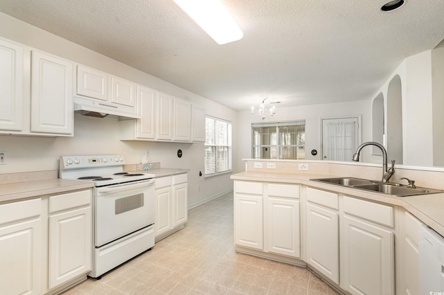 kitchen featuring white range with electric cooktop, white cabinets, sink, and a chandelier