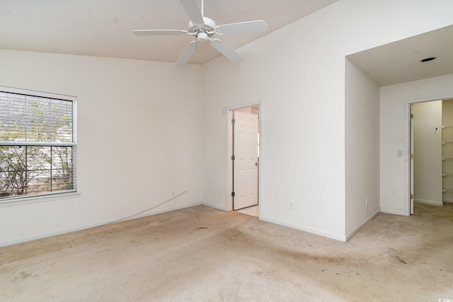 spare room with light carpet, vaulted ceiling, and ceiling fan