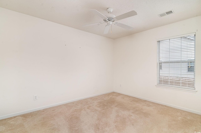 carpeted spare room featuring ceiling fan and a textured ceiling