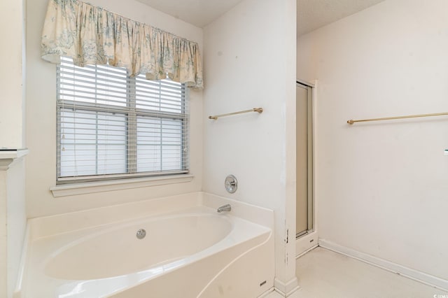 bathroom with tile patterned floors, separate shower and tub, and a textured ceiling