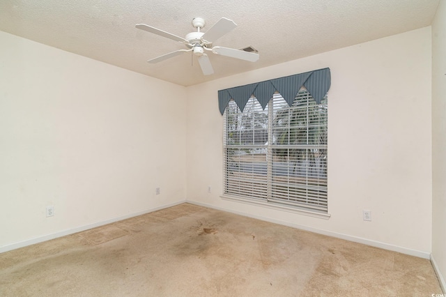 carpeted empty room featuring ceiling fan and a textured ceiling