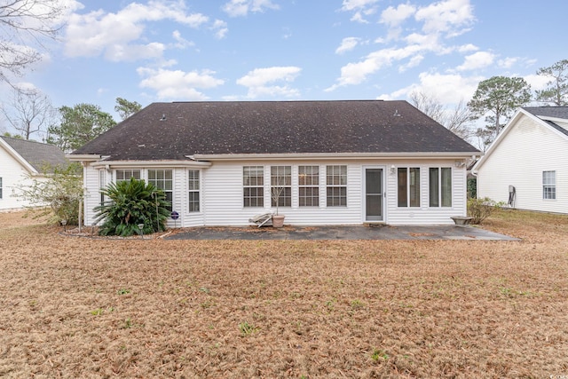 back of property with a lawn and a patio