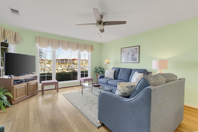 living room featuring light hardwood / wood-style flooring and ceiling fan