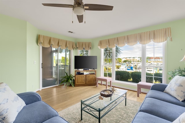 living room with ceiling fan and light hardwood / wood-style flooring