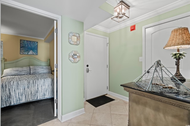 tiled foyer featuring ornamental molding and an inviting chandelier