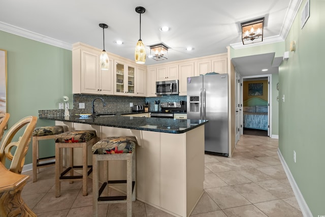 kitchen with ornamental molding, tasteful backsplash, decorative light fixtures, kitchen peninsula, and stainless steel appliances