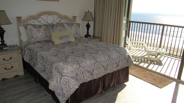 bedroom featuring a water view and hardwood / wood-style flooring