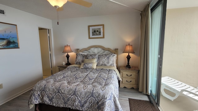 bedroom with hardwood / wood-style floors, a textured ceiling, and ceiling fan