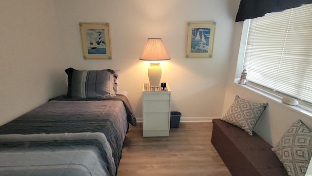 4719 S Ocean Blvd Unit 609, North Myrtle Beach, SC 29582 - bedroom featuring wood finished floors, multiple windows, and baseboards