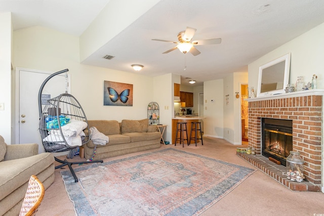 carpeted living room with ceiling fan and a brick fireplace