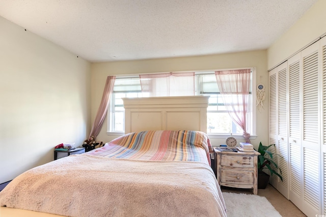 carpeted bedroom featuring a textured ceiling and a closet