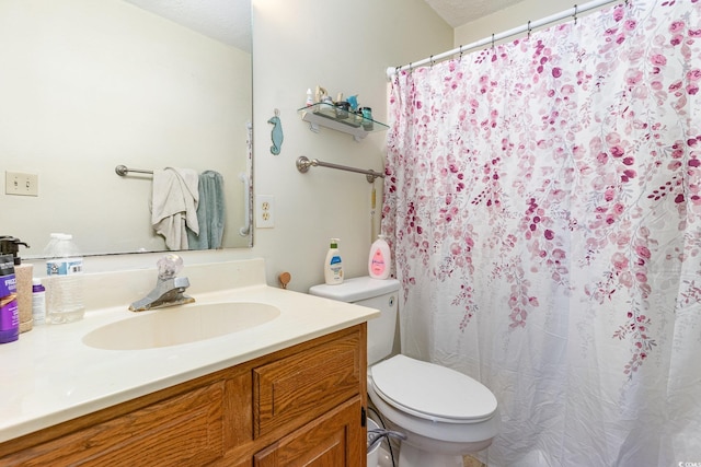 bathroom featuring a textured ceiling, vanity, and toilet