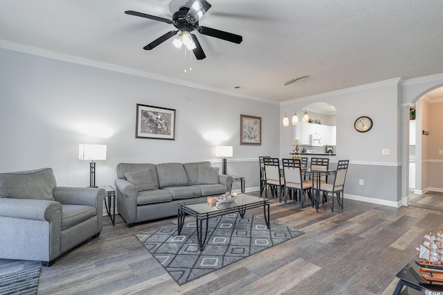 living room with a textured ceiling, dark hardwood / wood-style floors, ceiling fan, and crown molding