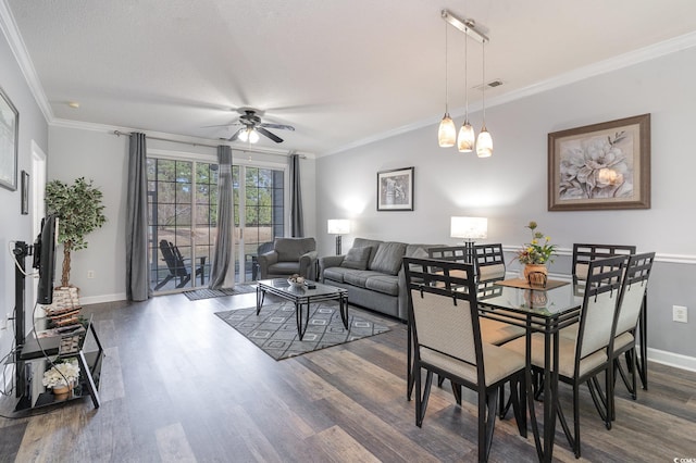 dining room with a textured ceiling, ceiling fan, crown molding, and dark wood-type flooring