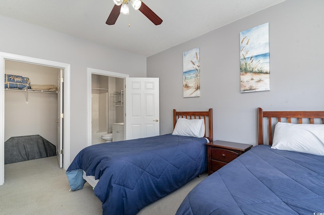 carpeted bedroom with a walk in closet, ceiling fan, a closet, and ensuite bathroom